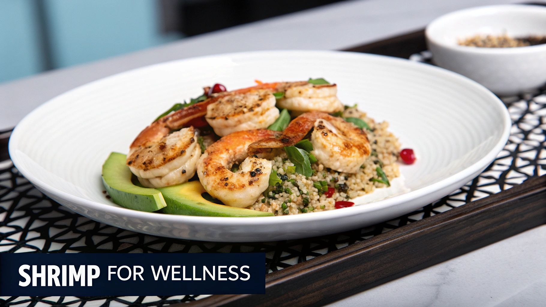 A healthy plate of grilled shrimp and quinoa with avocado slices and pomegranate seeds on a decorative tray.
