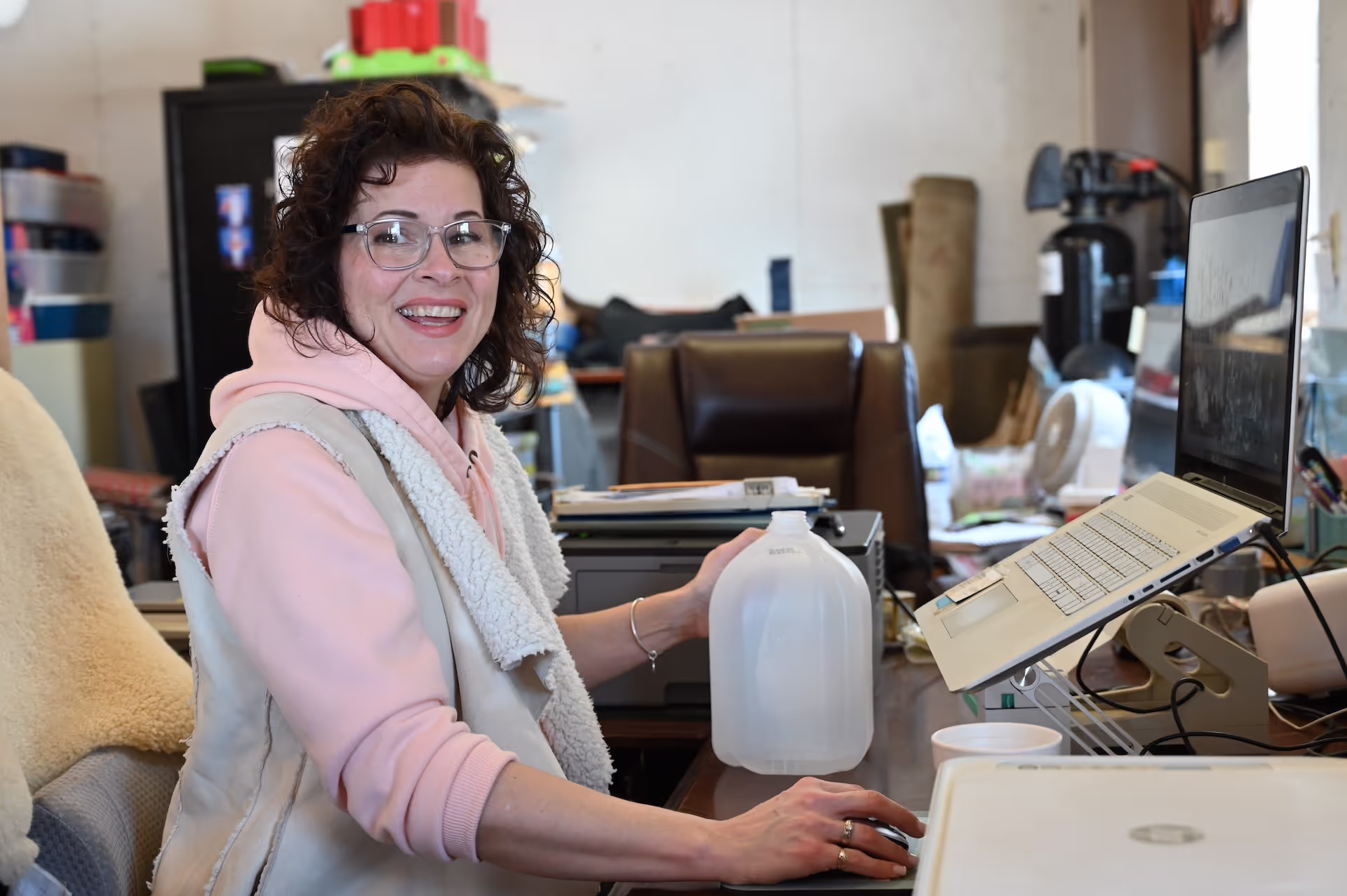 Cat James behind computer answering calls and customer service issues for Wilson Creek Auctions.