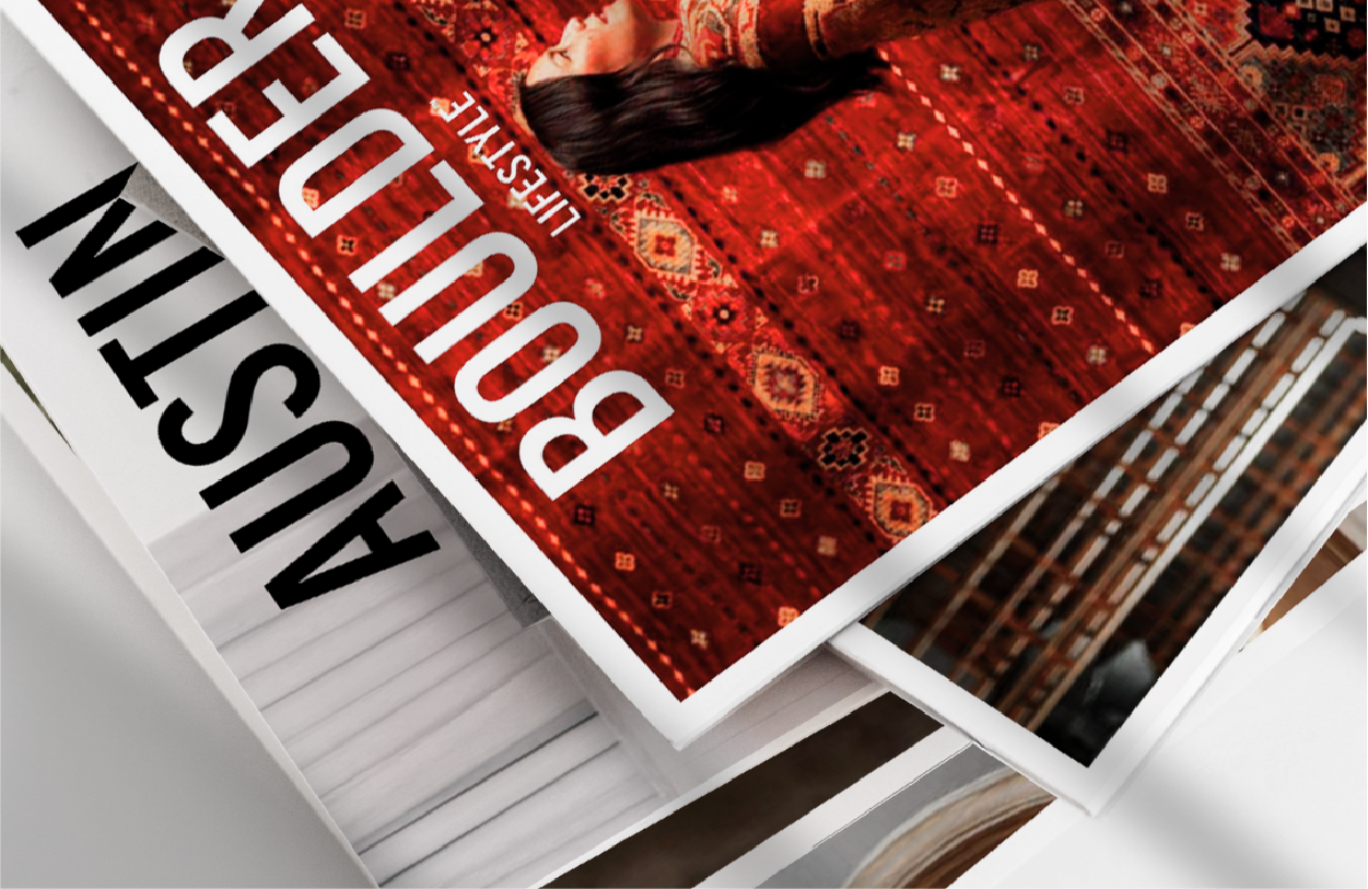 Elite Status Title: shows a stack of magazines laying atop one another on a table.
