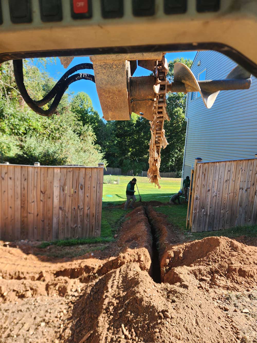 a drill that has dug a line for drainage pipes to be placed