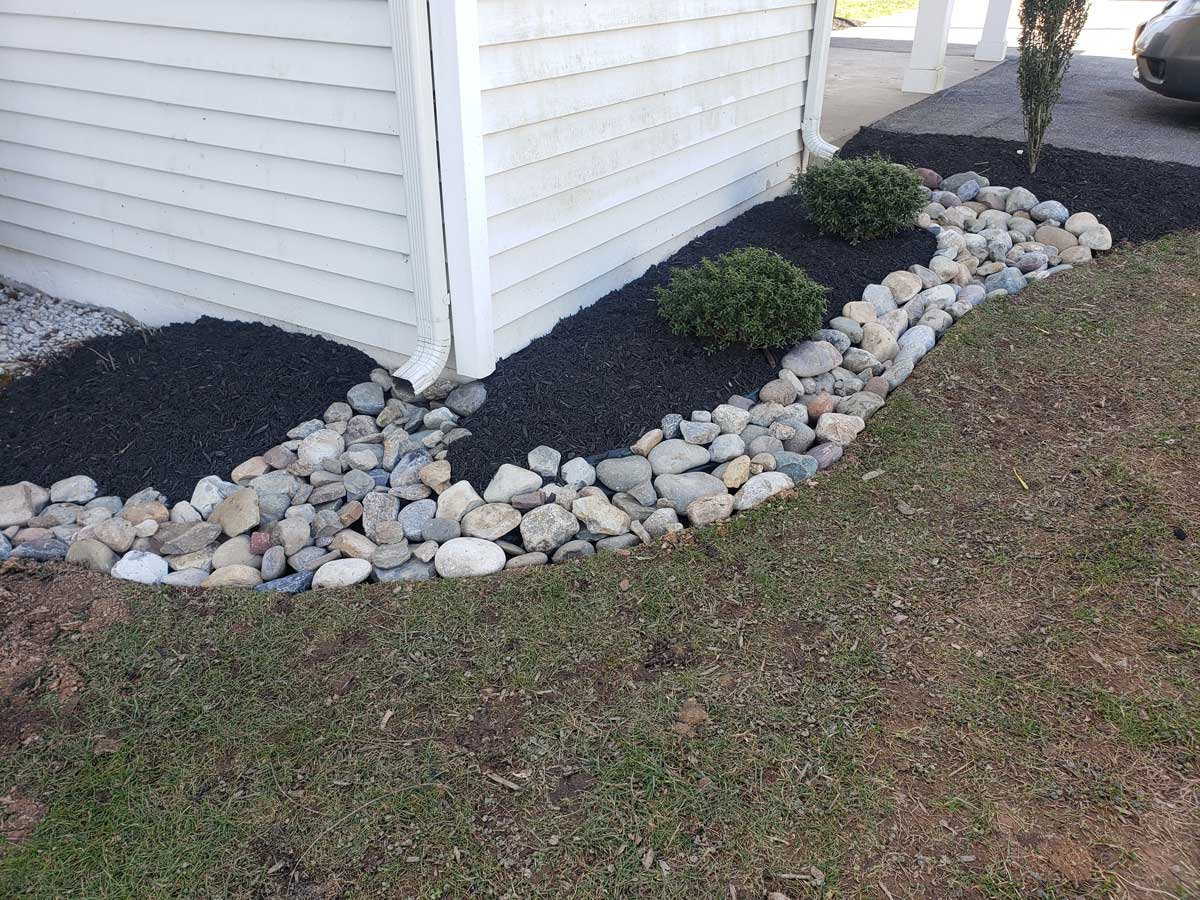 rocks hardscaped onto flower bed for better drainage