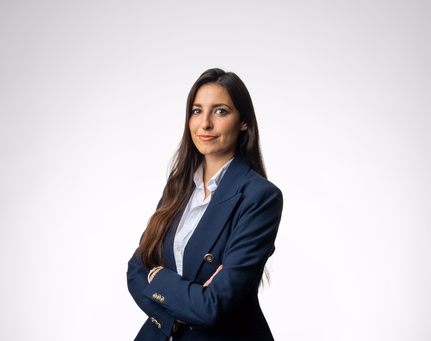 Portrait d'une femme d'affaires aux cheveux longs, portant un blazer bleu marine et une chemise blanche.