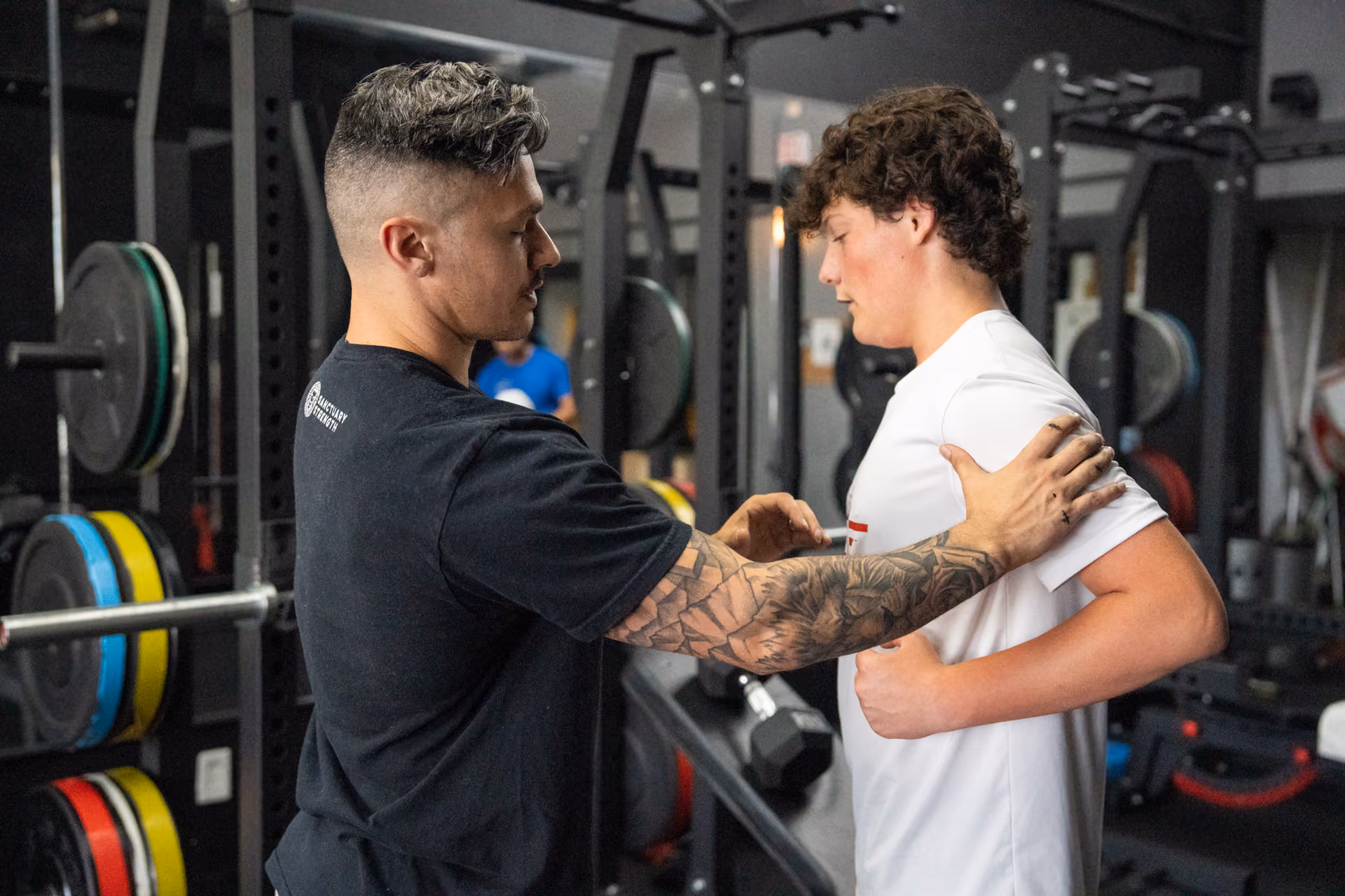 A personal trainer coaching a young athlete on form at Sanctuary Strength in Franklin, TN