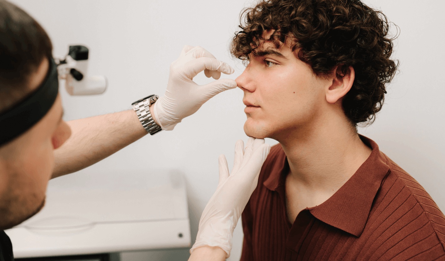 ENT surgeon examining a patient’s nose before septoplasty in Los Angeles to correct a deviated septum.