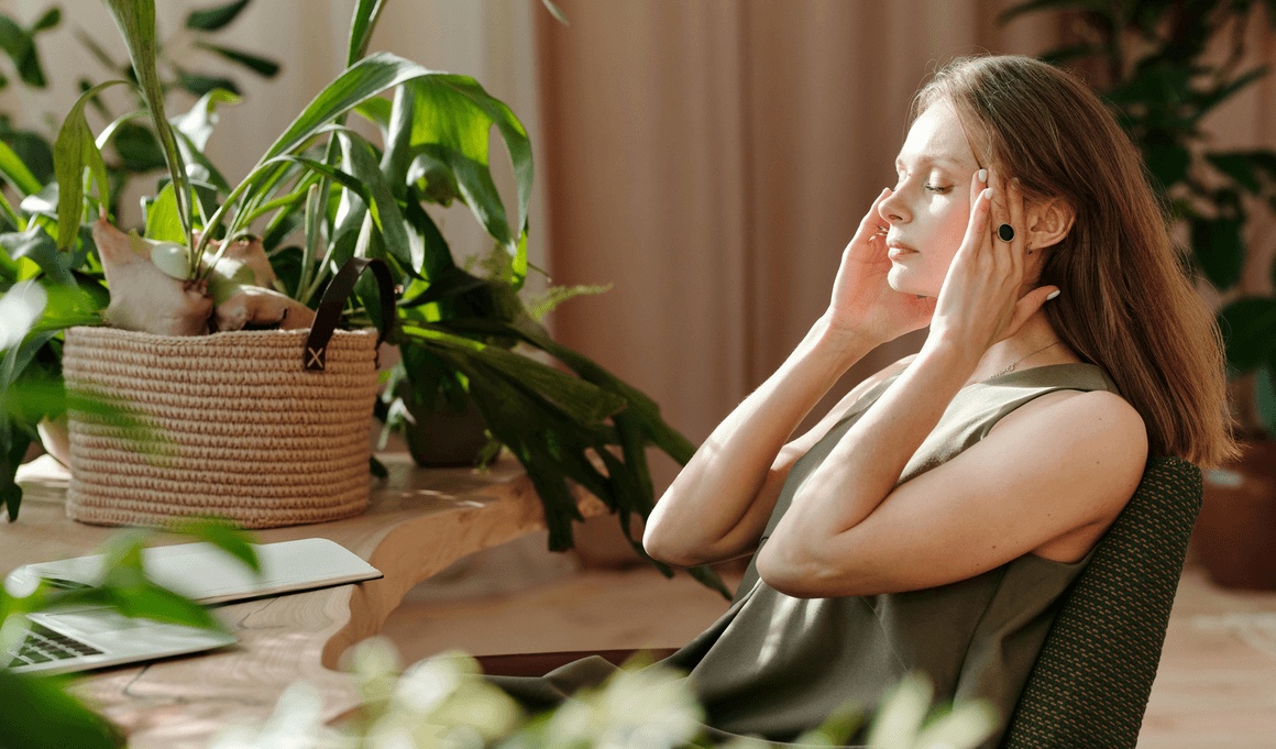 Woman holding her temples while experiencing a sinus headache at home, seeking relief from the best sinus doctor in Santa Monica.