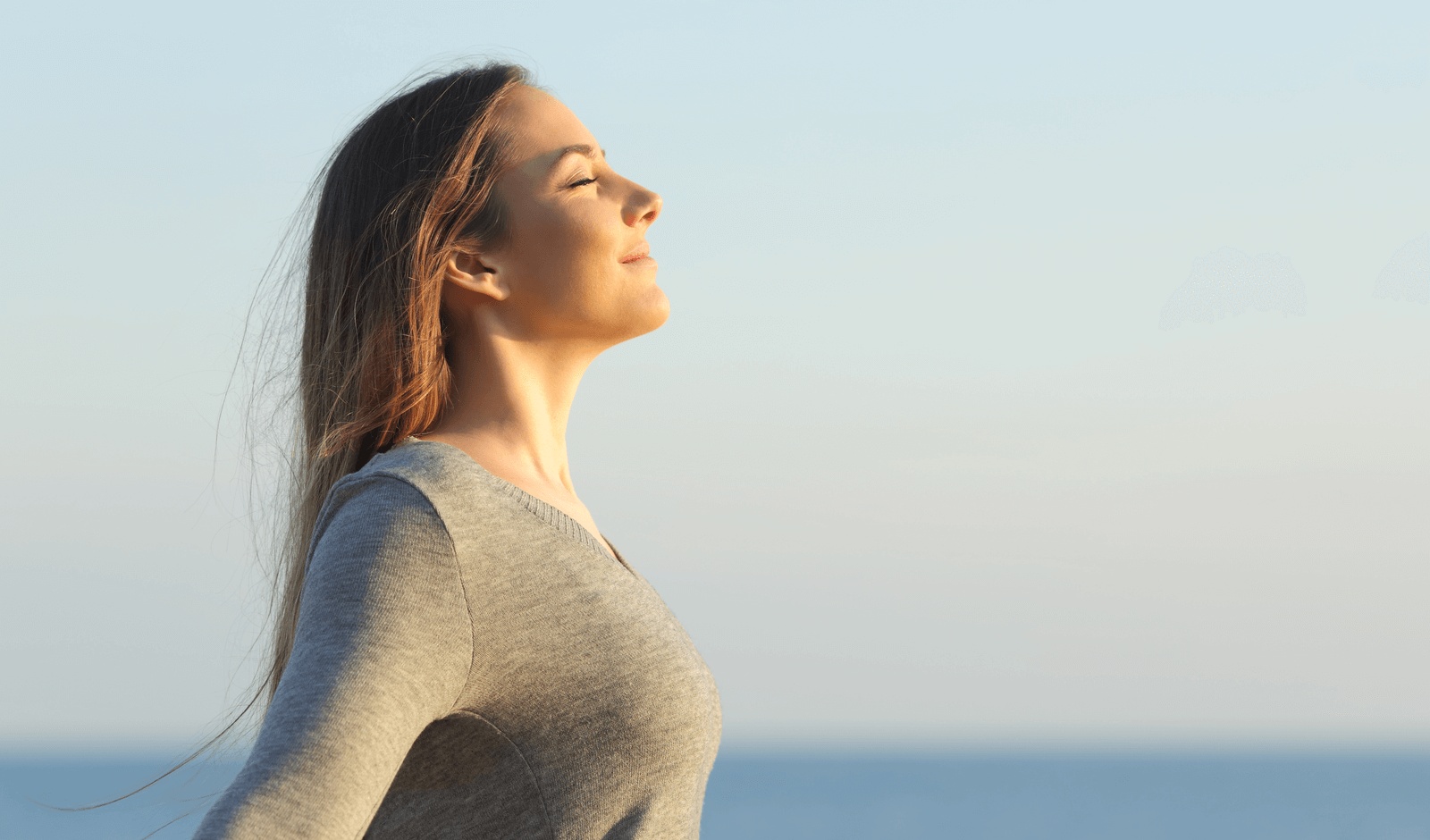 Woman breathing deeply outdoors and experiencing relief from sinusitis, illustrating improved sinus health with care from the best ENT in Los Angeles.