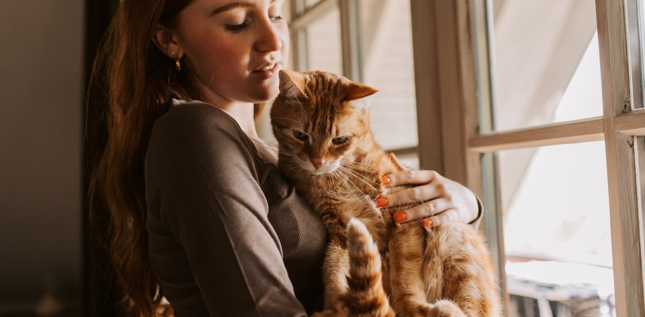 Woman holding her sad cat