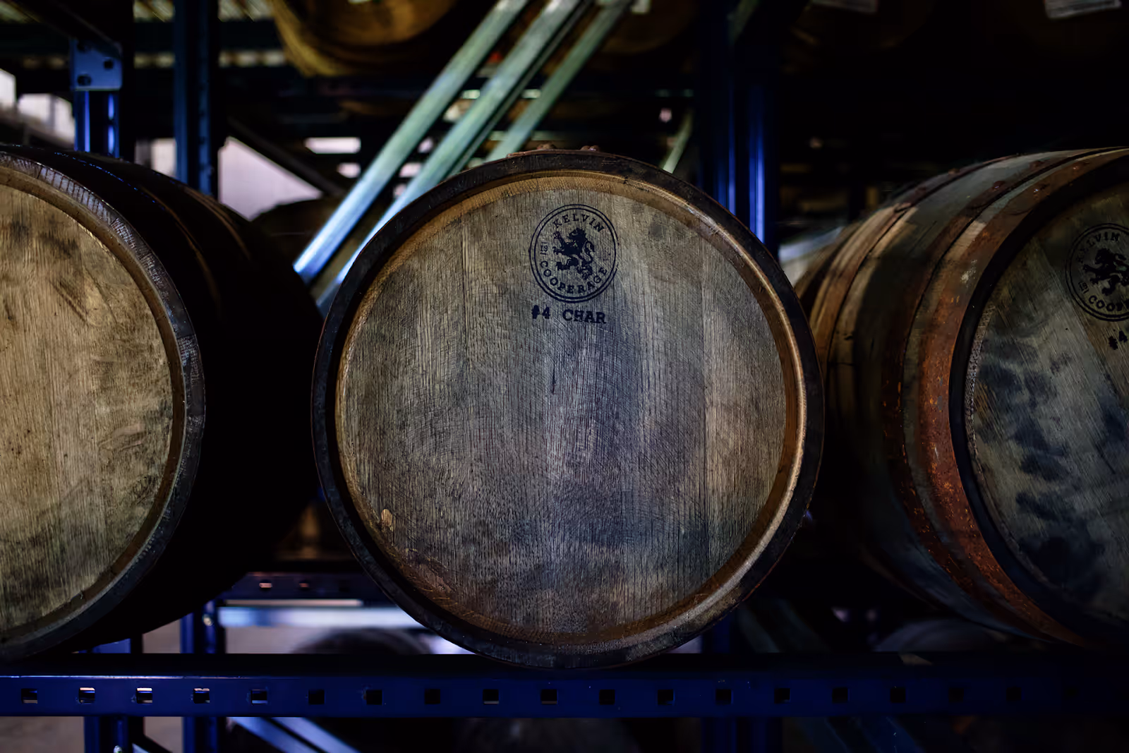 Aged single barrels stacked in a Kentucky rickhouse, each developing a unique bourbon expression over six years