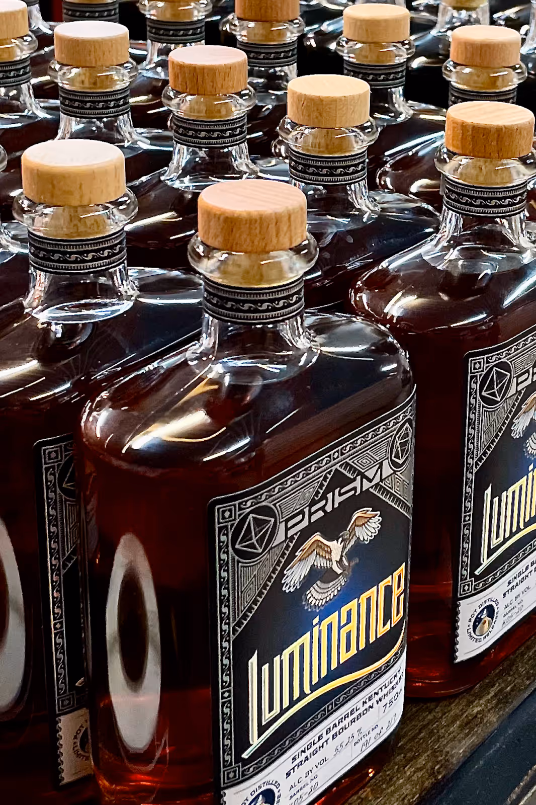 Luminance single barrel bourbon bottles on display, showing the deep amber color of pot-distilled Kentucky bourbon