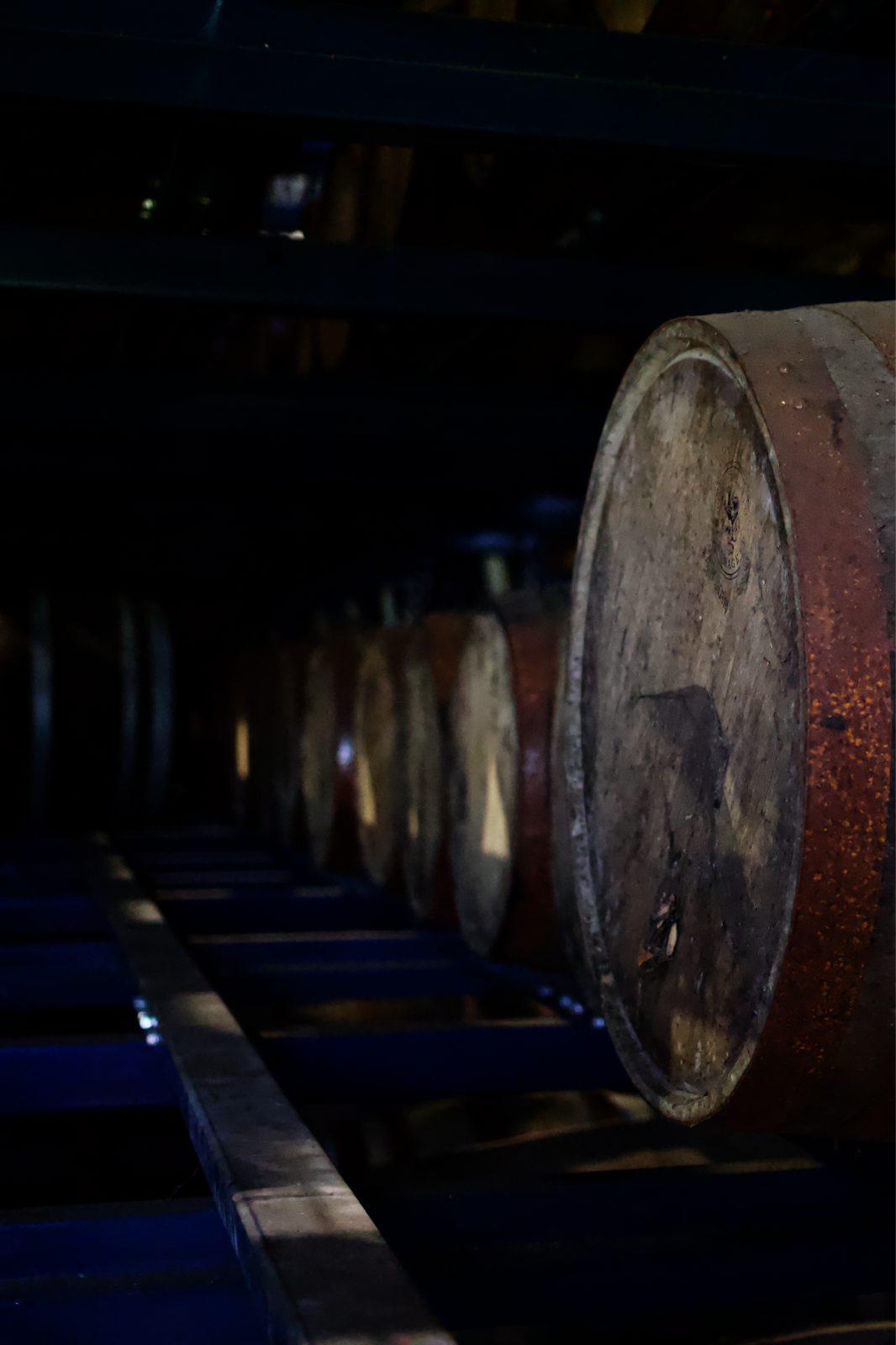 Rows of bourbon barrels aging in a traditional Kentucky rickhouse, stacked from floor to ceiling