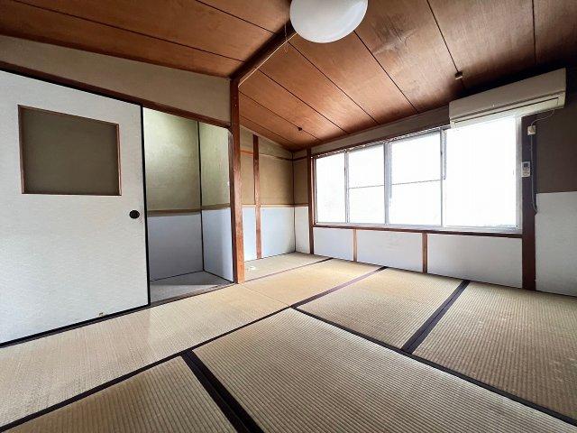 Traditional Japanese tatami room with wooden ceiling, sliding doors, and large window