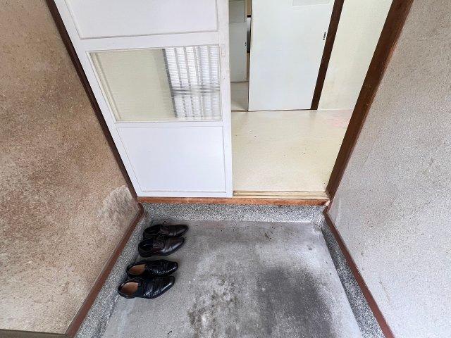 Traditional Japanese genkan (entrance area) with concrete floor and shoe storage space