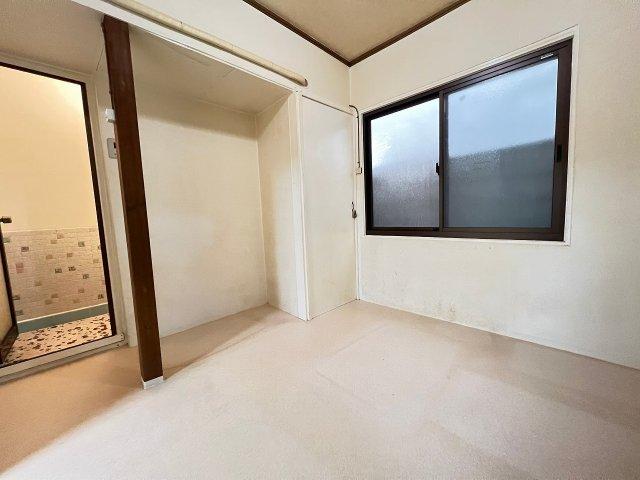 Empty room with white walls, wooden beam support, and sliding window