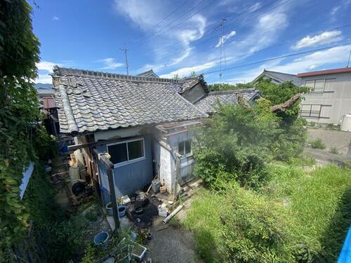 Traditional Japanese Home Exterior – A classic wooden house with a tiled roof in a peaceful rural setting.