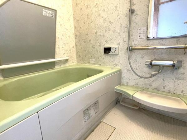 Traditional Bath Area – A bathroom with a deep soaking tub and tiled walls.