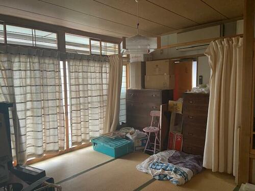 Tatami Room with Shoji Doors – A well-lit tatami room featuring wooden beams and sliding doors.