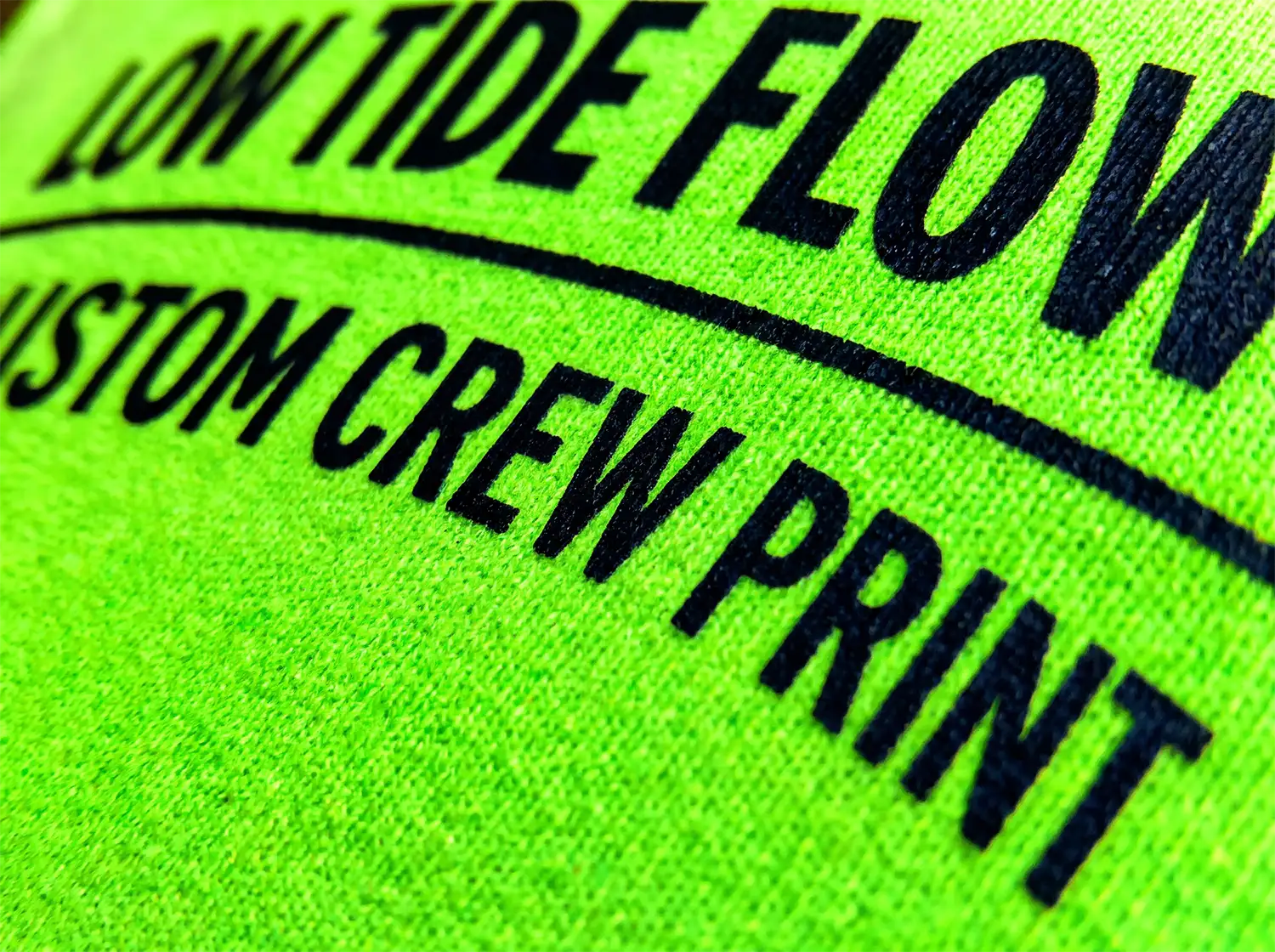 Close-up of a green hi-vis shirt with a black screen-printed logo