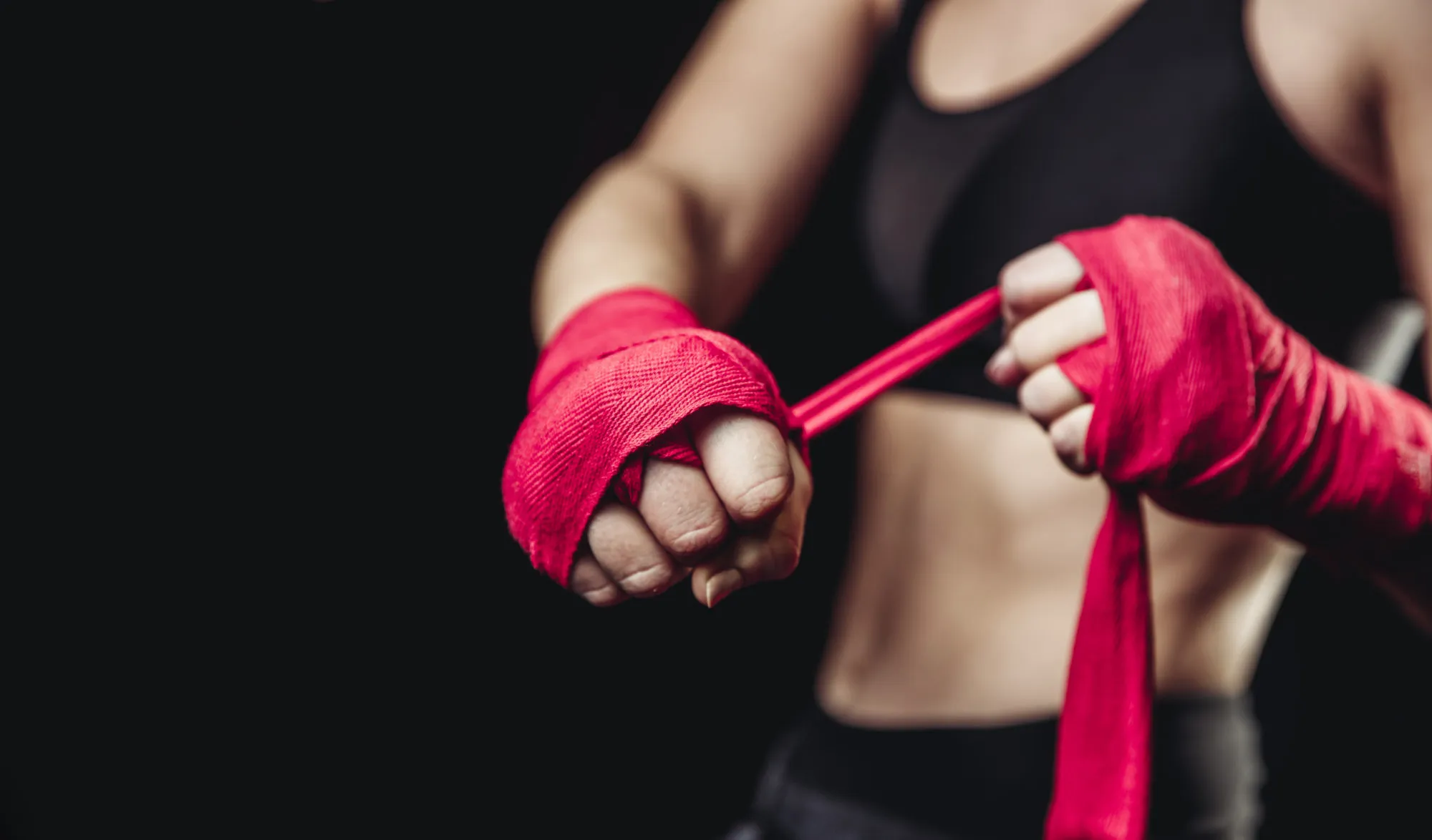 a woman in a black sports bra top and red boxing gloves