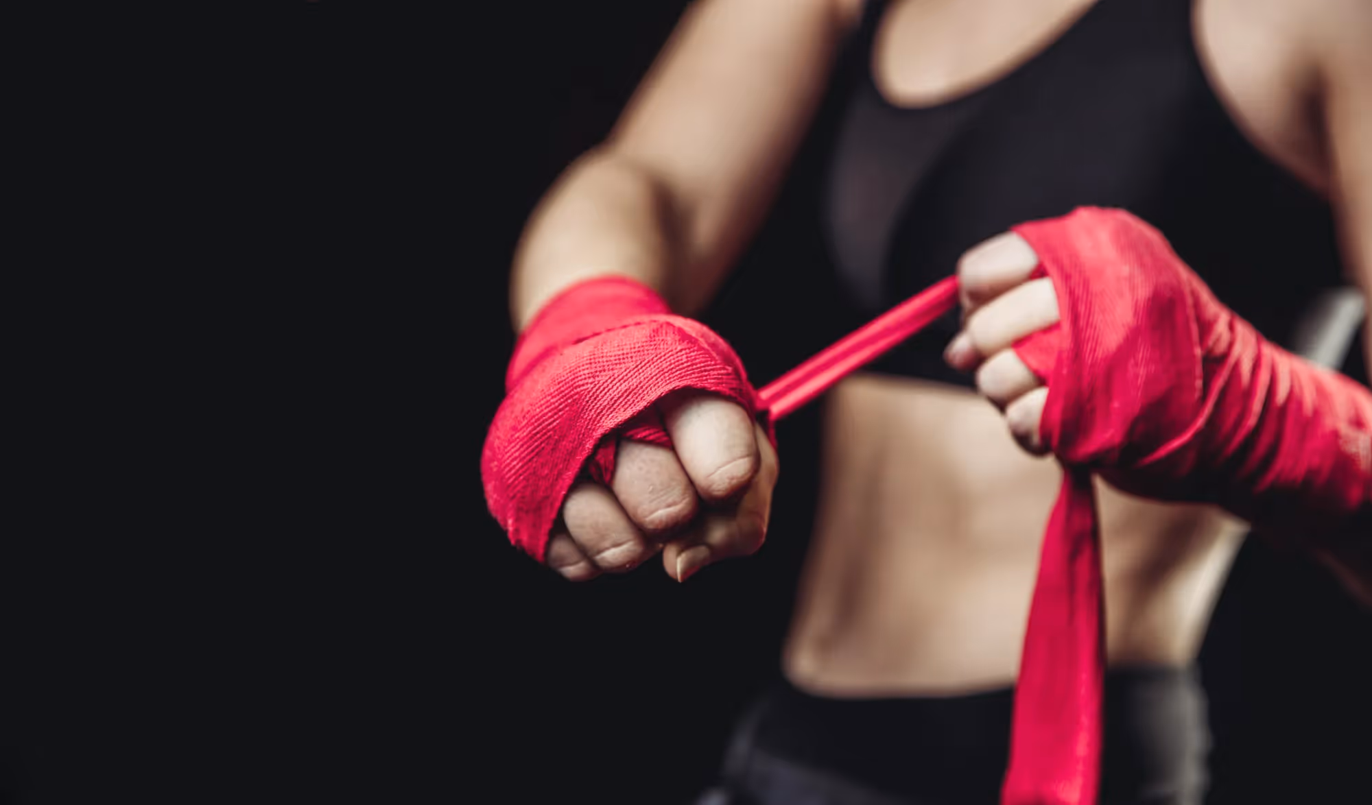 a woman in a black sports bra top and red boxing gloves