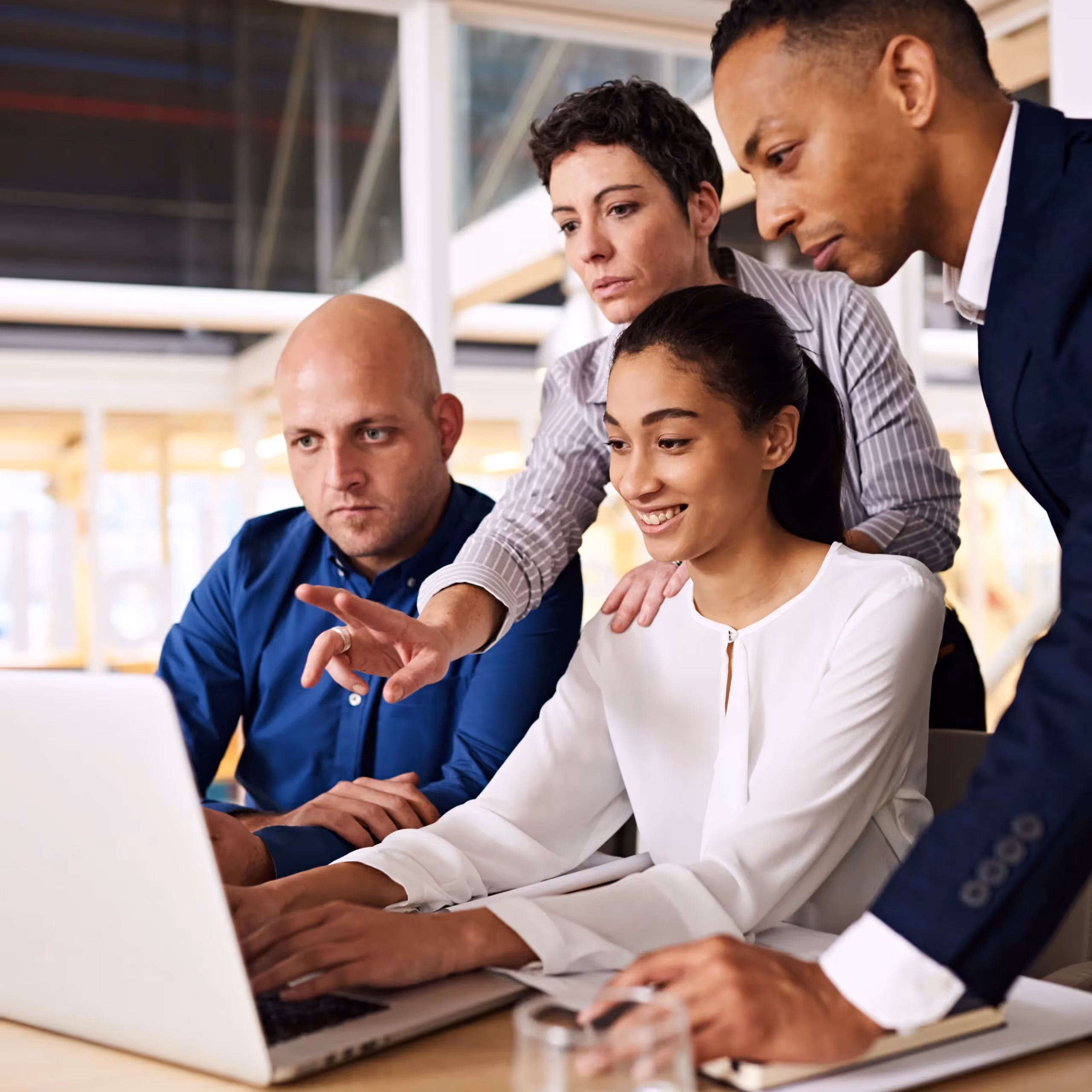 a group of people looking at a laptop