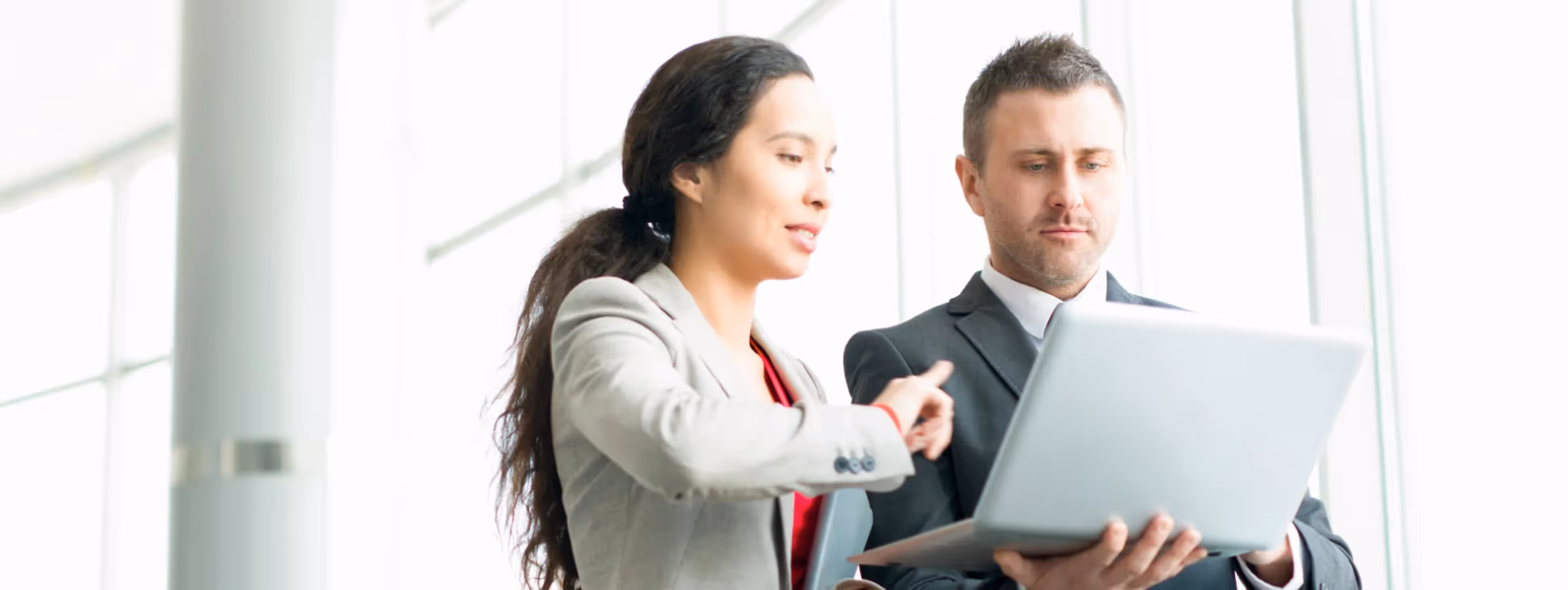 a man and woman looking at a laptop