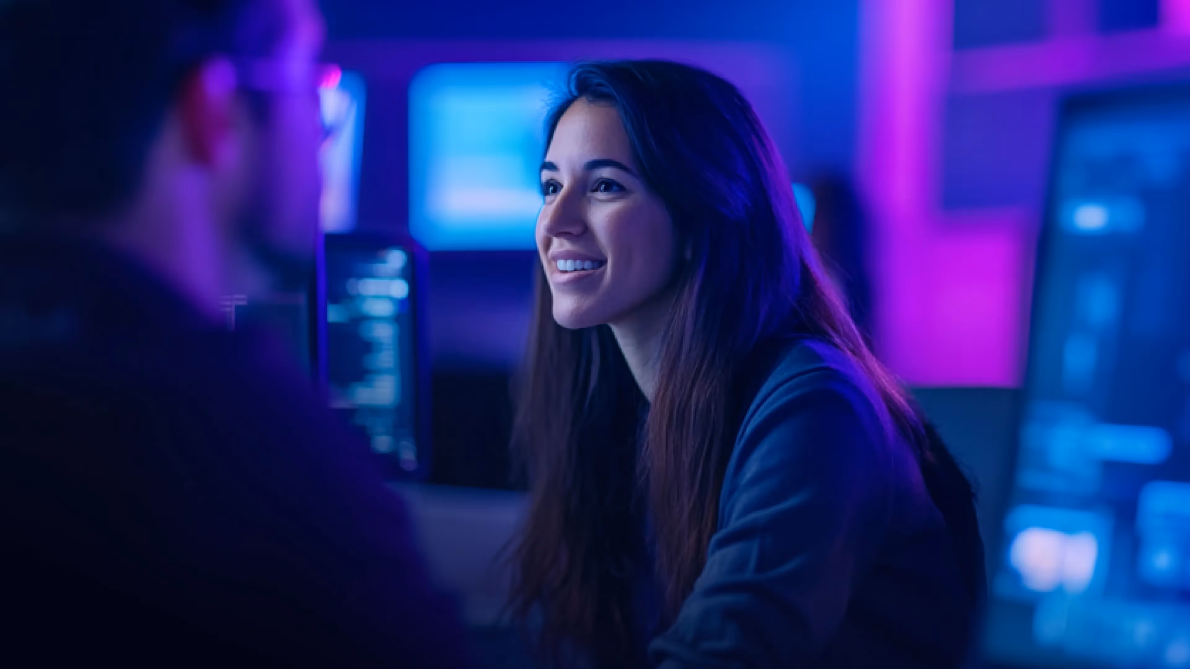 cybersecurity analyst smiles at her computer monitor as she ensures supply chain security