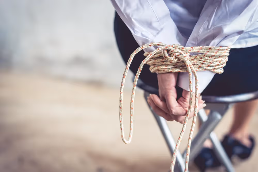 a person tying a rope around a chair