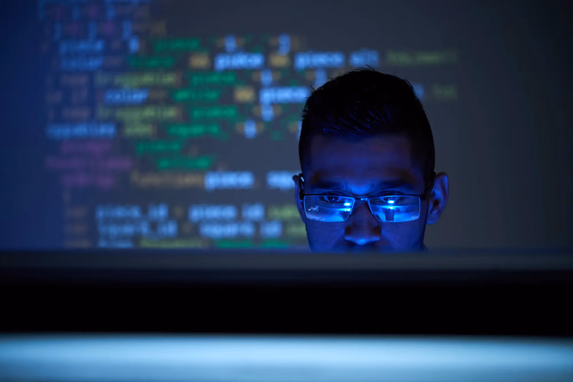 a man in glasses looking at a laptop