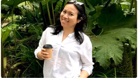a woman holding a cell phone in a forest