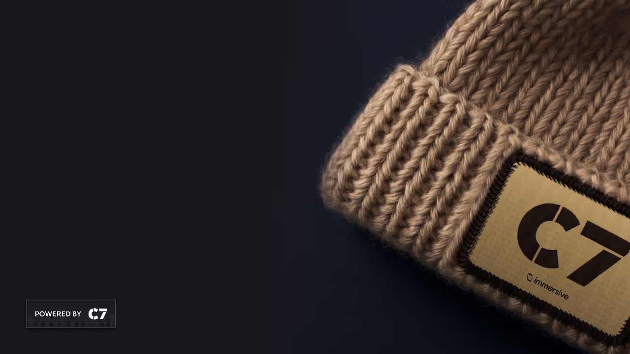 Close-up of a beige knit beanie with a stitched rectangular label reading C7 on a dark surface.