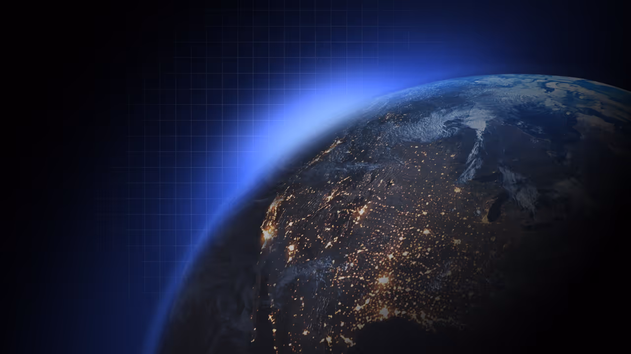 Night view of North America with city lights glowing under a blue atmospheric glow in space.