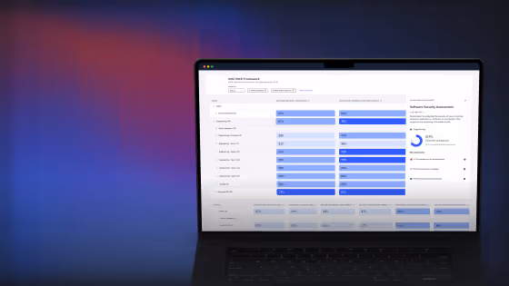 Laptop screen showing a cybersecurity framework dashboard with risk and score metrics and charts.