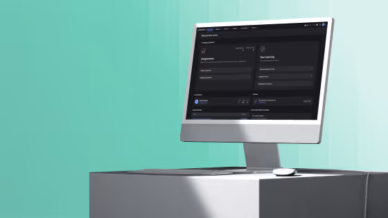 Modern computer on gray pedestal showing a dark-themed dashboard with assignments and learning sections.