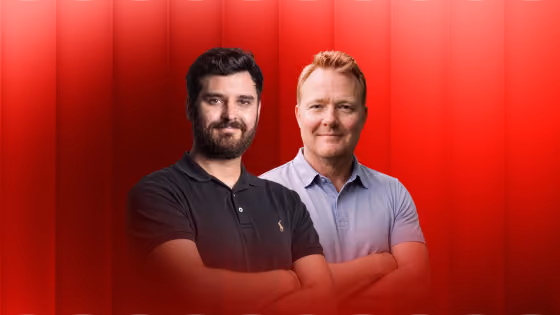 Two men standing side by side with arms crossed against a red gradient background.