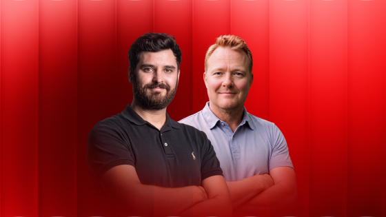 Two men standing side by side with arms crossed against a red gradient background.