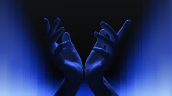 Two open hands illuminated by blue light.