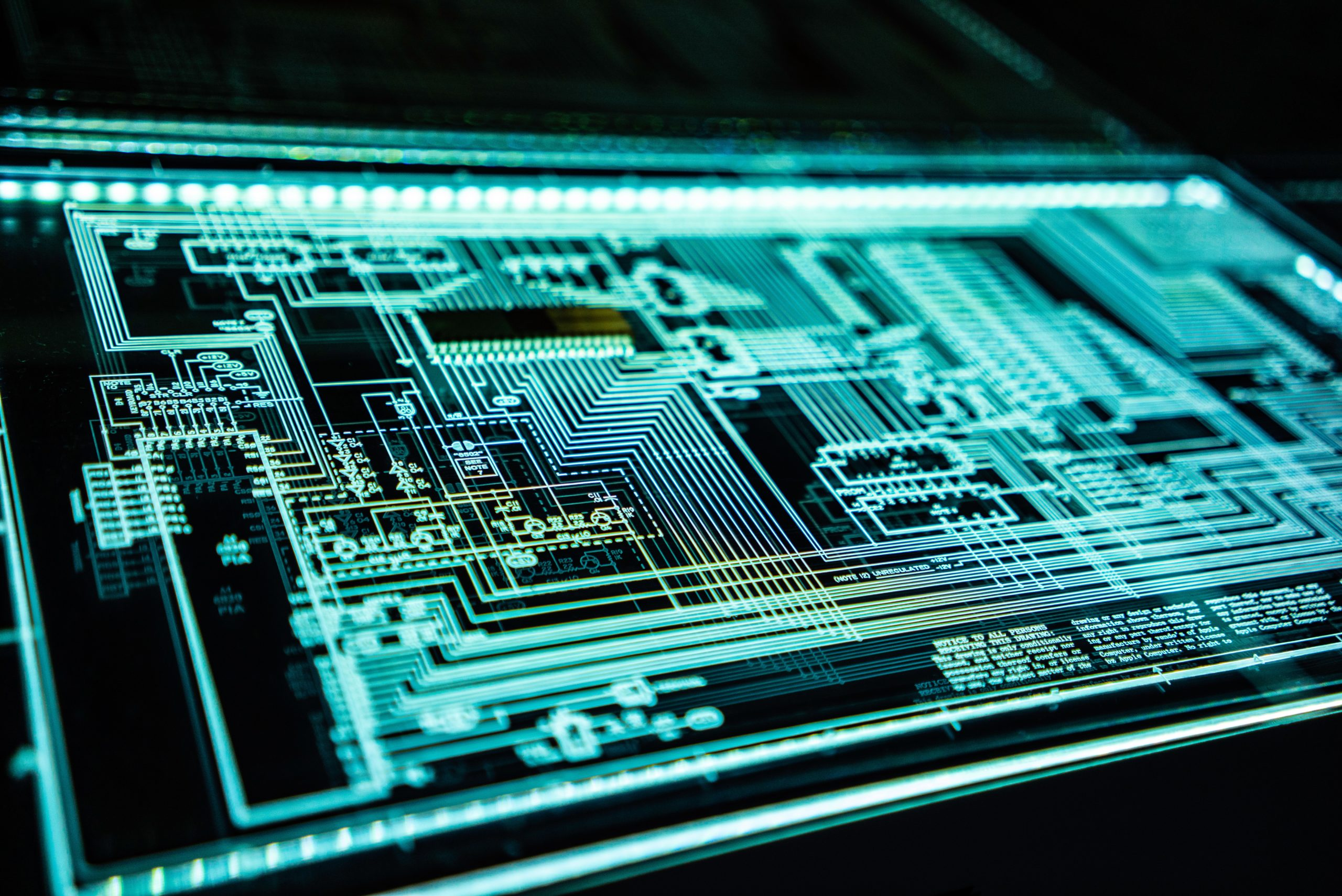 Close-up of an illuminated digital circuit board with intricate wiring and components.