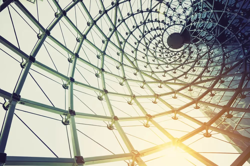 Sunlight shining through a curved glass and steel roof.