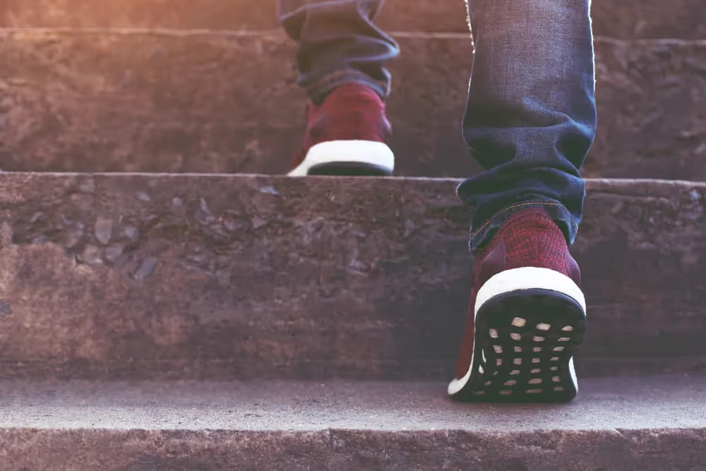Close-up of a person climbing stone steps.