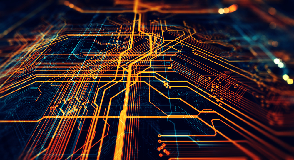 Close-up of glowing orange circuit board pathways on a dark blue background.