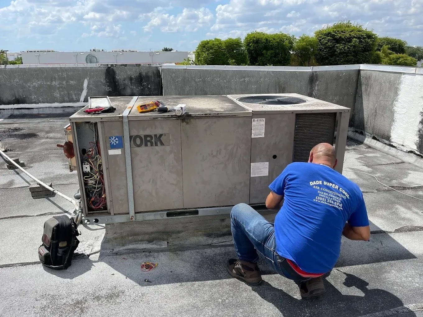 Technician performing an AC tune-up in a Miami home, emphasizing energy efficiency and reliability