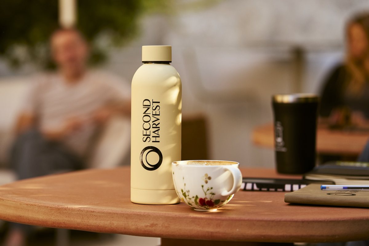 A Second Harvest water bottle on a cafe table