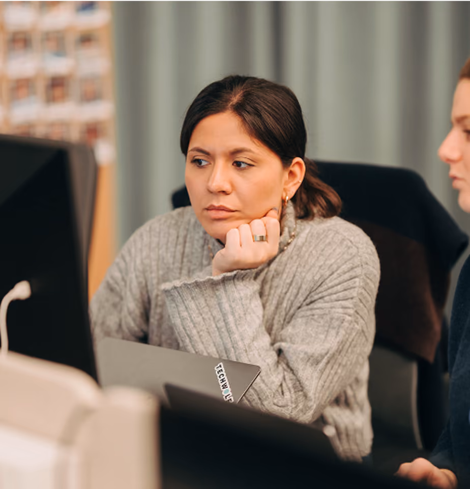 Two women discussing something on a desktop screen