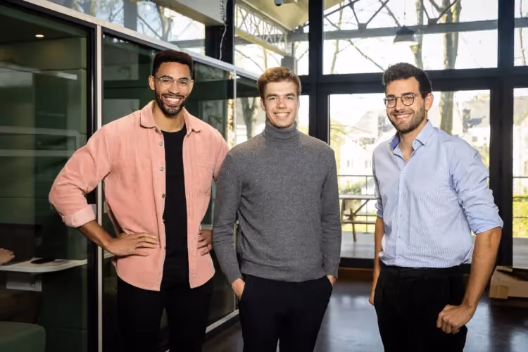 TechWolf's three co-founders standing together in a bright office with tall windows
