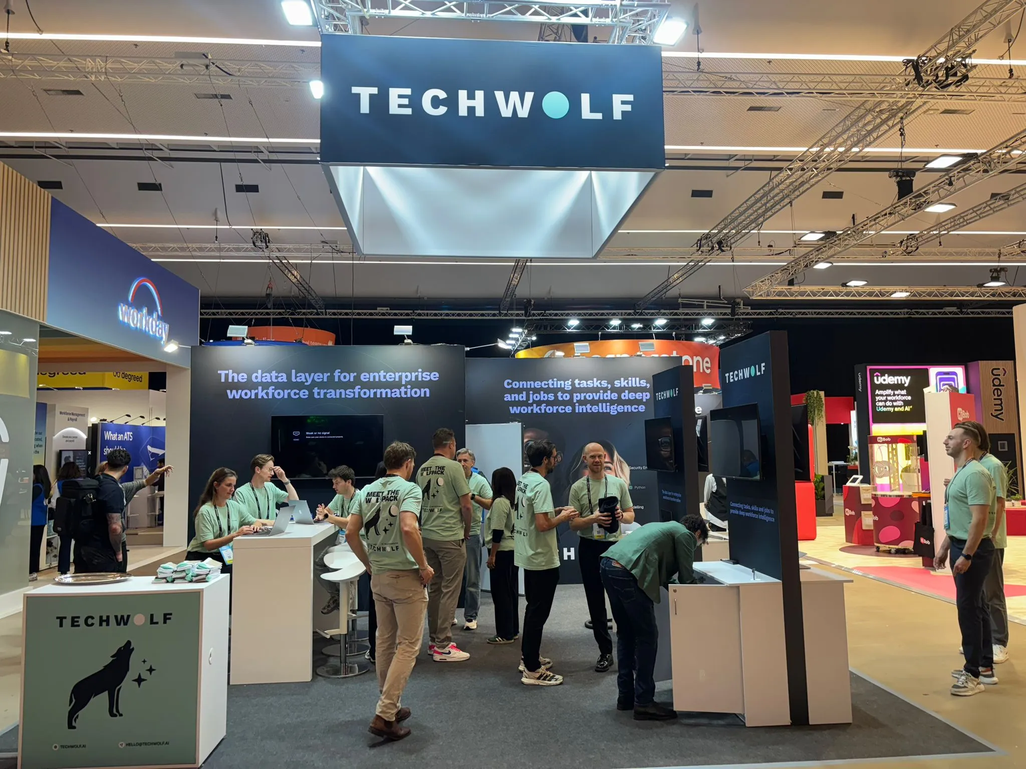 TechWolf trade-show booth with staff in mint T-shirts under a large TECHWOLF sign