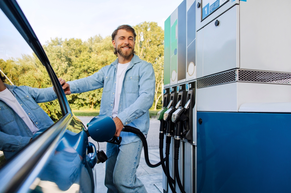 Happy man refueling car