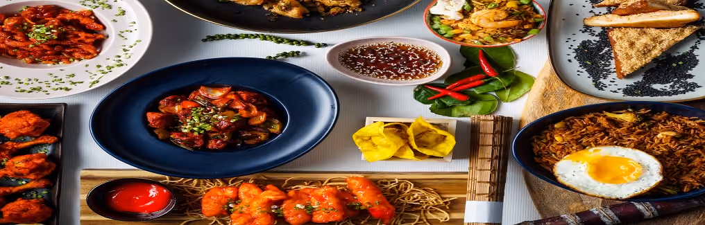 An overhead spread of various Asian dishes, including fried rice with an egg