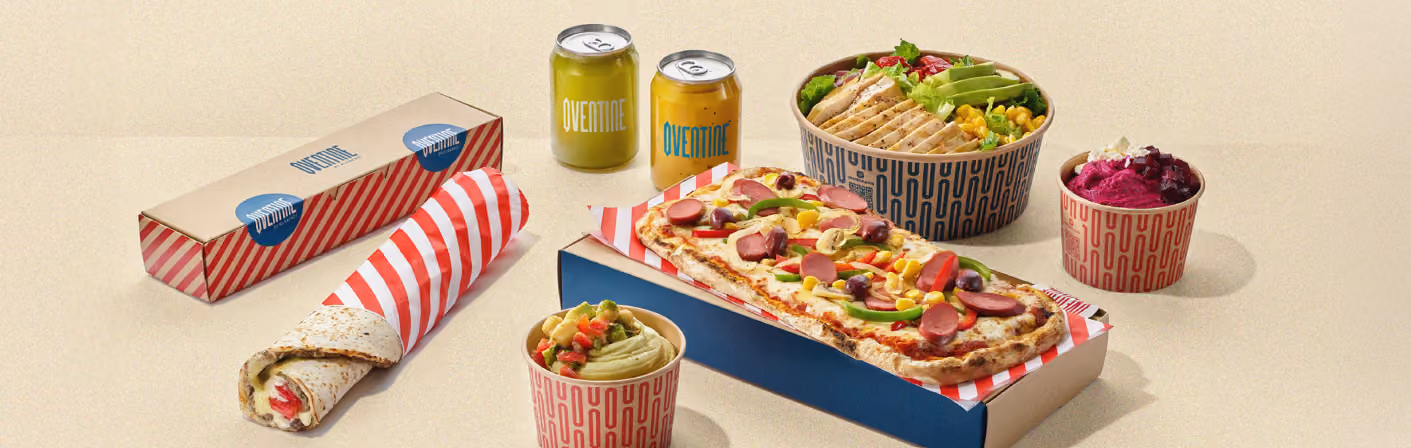 A spread of takeaway food including a wrap, a long pizza (Pide), salads, and dips
