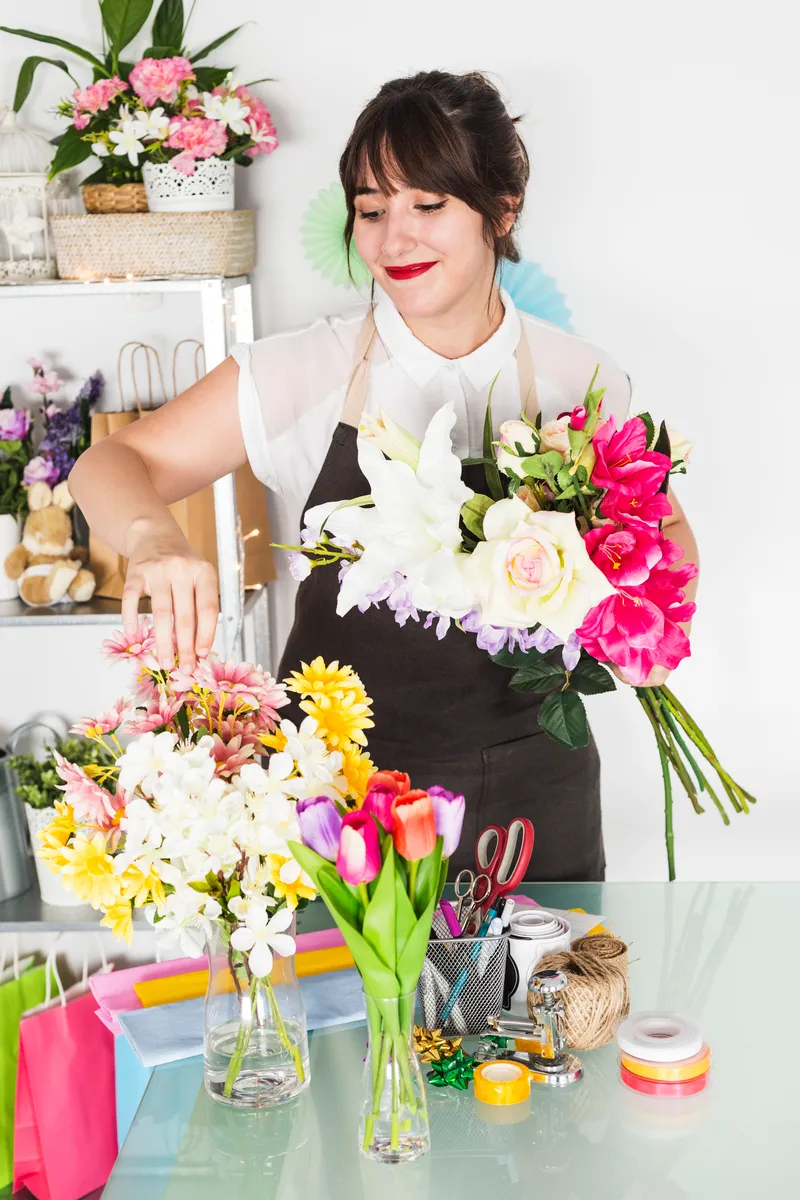 Fleuriste artisans qui fabrique un bouquet de fleurs.