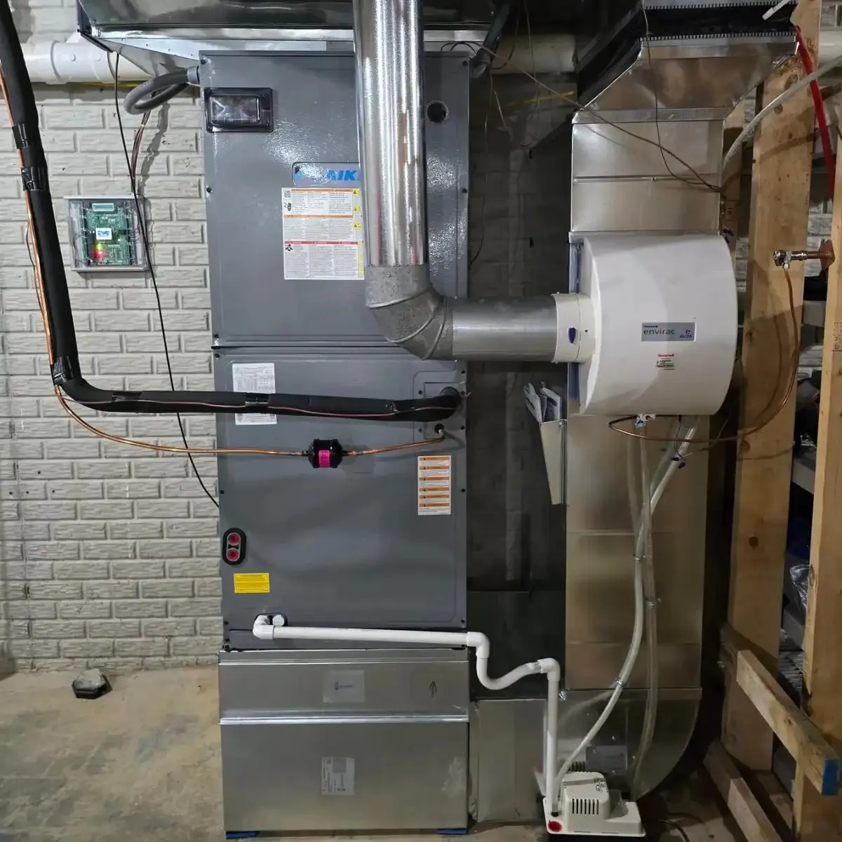 A basement HVAC system with visible ducts and pipes.